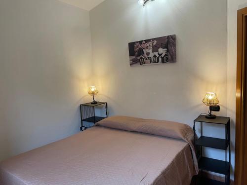 - une chambre avec un lit et deux lampes murales dans l'établissement la villetta del sole, à Ovile la Marinella