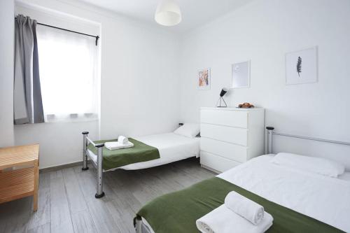 辛特拉的住宿－Sintra Sweet Apartment II - Free Parking，一间白色卧室,配有两张床和窗户
