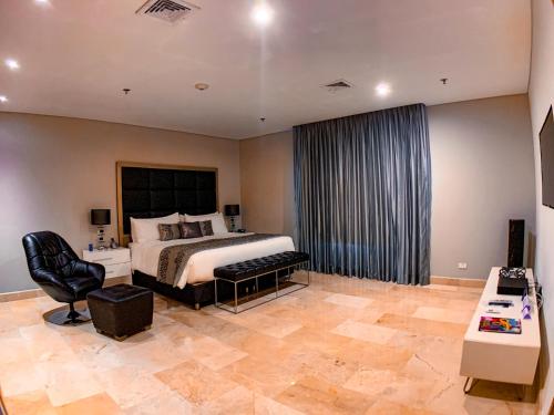 a bedroom with a bed and a chair in a room at Hotel Dann Carlton Barranquilla y Centro de Convenciones in Barranquilla