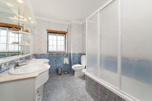 een badkamer met 2 wastafels, een toilet en een douche bij Casa do Monte Amarelo in Fátima