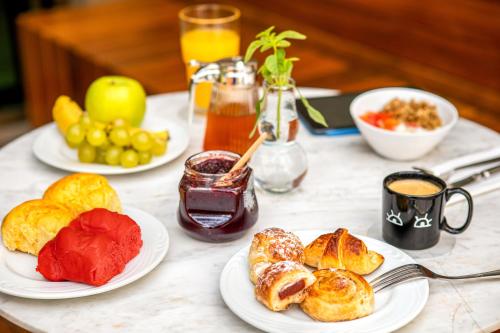 a table topped with plates of pastries and fruit at INNSiDE by Meliá São Paulo Iguatemi in Sao Paulo