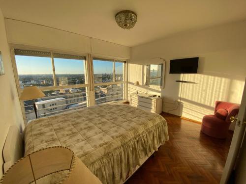 a bedroom with a large bed and a large window at Vista a Montevideo in Montevideo