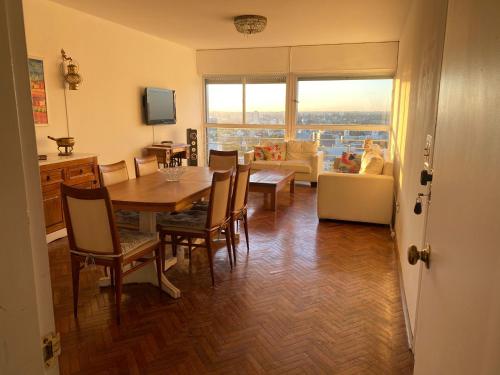 - une salle à manger avec une table, des chaises et un canapé dans l'établissement Vista a Montevideo, à Montevideo