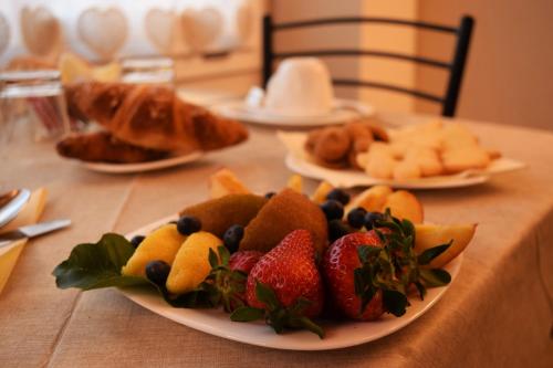 a table topped with plates of fruit and pastries at B&B Da Nora in Mallare