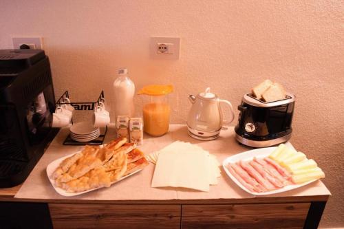 a counter top with bread and cheese and other foods at B&B Da Nora in Mallare