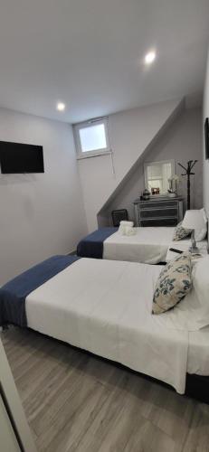 a bedroom with two beds and a television in it at RIVERINN QUARTOS No Centro Histórico De Portimão RC in Portimão