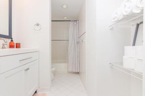 een witte badkamer met een toilet en een wastafel bij One Bedroom Apartment - with Parking & Balcony - Heart of Wynwood in Miami
