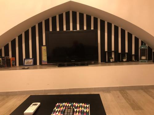 sala de estar con TV y mesa con mando a distancia en Il Campanile, en Agrigento