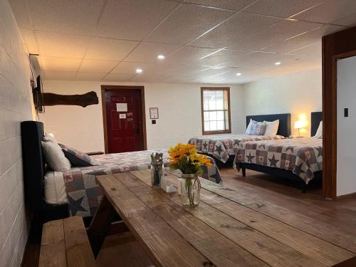 Cette chambre comprend 2 lits et une table fleurie. dans l'établissement Big South Fork Lodge, 