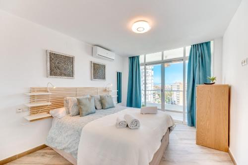 sypialnia z łóżkiem i dużym oknem w obiekcie VB Diana 1BR Marina & Sea views w mieście Benalmádena
