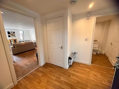 un soggiorno vuoto con porta bianca e pavimenti in legno di Joe Kelly Buildings B a Withernsea