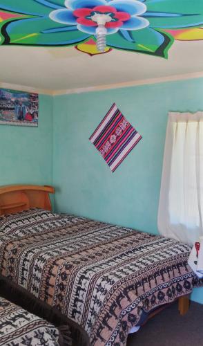 a bedroom with a bed and a ceiling at Dawn House - Lago Titicaca in Amantani