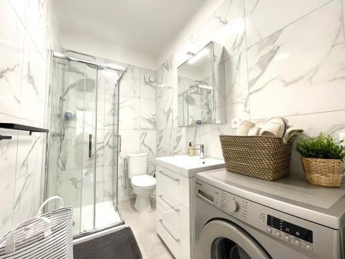 uma casa de banho branca com uma máquina de lavar roupa em Studio bord de mer 2 em Menton