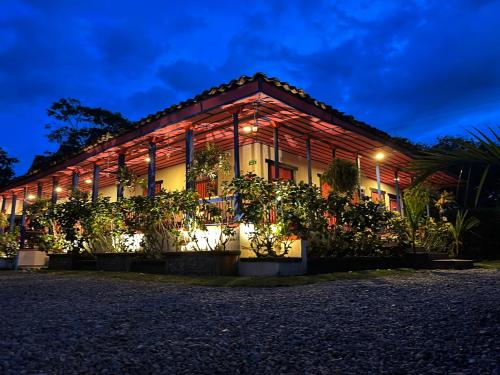 a building with plants in front of it at night at El Percal Hacienda Hotel in Montenegro