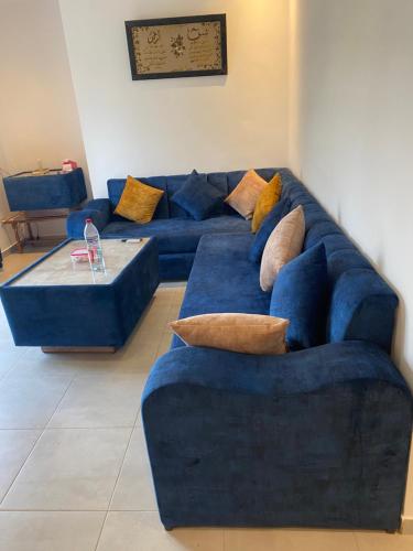 a living room with a blue couch with pillows at COSTAMAR in Martil