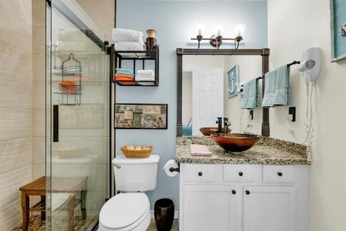 a bathroom with a toilet and a sink and a shower at Rain Dancer in South Padre Island