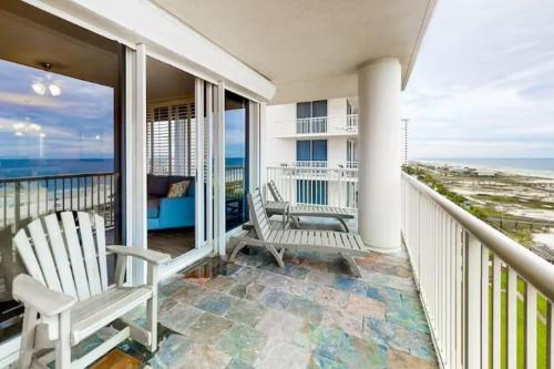 a balcony with two white chairs and a view of the ocean at The Beach Club - Doral #701 in Gulf Highlands