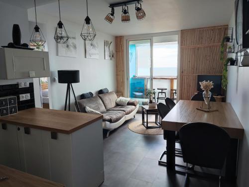 une cuisine et un salon avec une table et un canapé dans l'établissement Appartement Type 3 face mer, à Saint-Hilaire-de-Riez