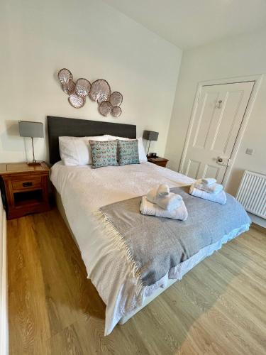 a bedroom with a bed with two towels on it at The Blue Door in Kirkcudbright