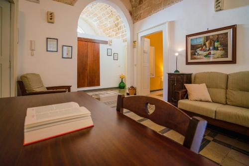 uma sala de estar com uma mesa e um sofá em B&B 'Nu Suennu - Centro storico di Maruggio em Maruggio