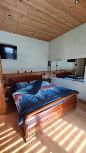 a bedroom with a large wooden bed in a room at Chez Pewee, beau duplex en ville, parc privé in Martigny-Ville