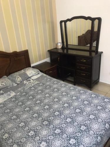 a bedroom with a bed and a dresser and a mirror at Ceuta fnideq in Fnidek