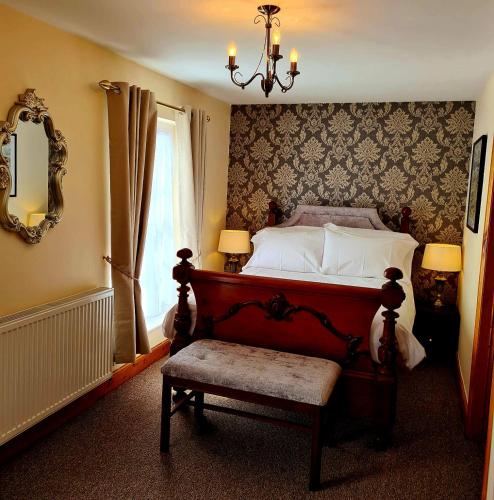 a bedroom with a bed and a chair and a chandelier at The St Crispin Inn in Worth