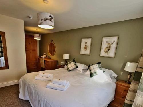 a bedroom with a large white bed with towels on it at The St Crispin Inn in Worth