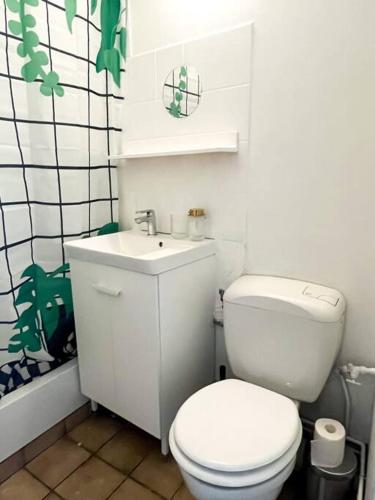 Joli studio fonctionnel في كايين: حمام به مرحاض أبيض ومغسلة