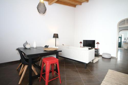 - un salon avec une table et un tabouret rouge dans l'établissement Birdy House, à Faro