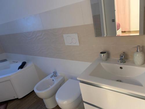 a white bathroom with a sink and a toilet at R Home in Ischia