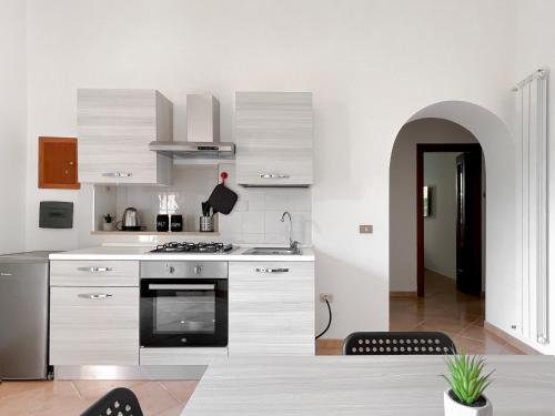 eine Küche mit weißen Schränken und einem Herd mit Backofen in der Unterkunft Nea apartment in Rom