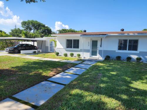 a white house with a car parked in front of it at JBMANORS in Fort Lauderdale