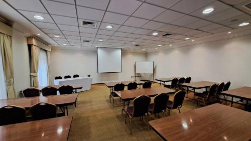a conference room with tables and chairs and a screen at Hotel Diego de Almagro Copiapo in Copiapó