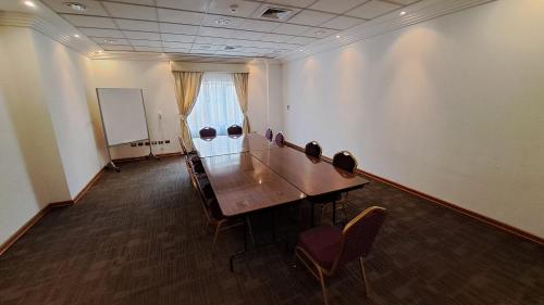 a conference room with a wooden table and chairs at Hotel Diego de Almagro Copiapo in Copiapó