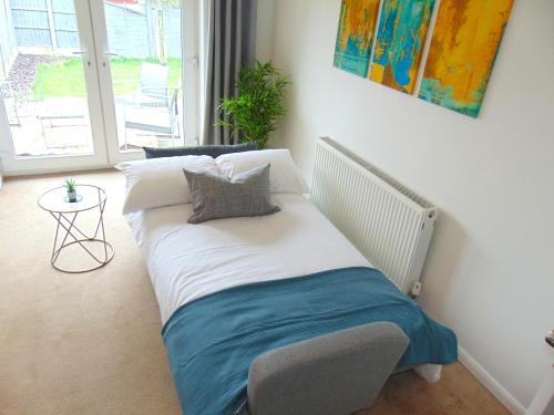a bed sitting in a room with at Cosy Two Bedroom Bungalow in Hutton Brentwood with Free Parking & Garden in Hutton