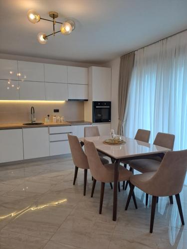 a kitchen and dining room with a table and chairs at Lux Apartment Jovanovic in Tivat