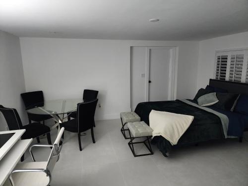 Schlafzimmer mit einem Bett, einem Tisch und Stühlen in der Unterkunft JBMANORS in Fort Lauderdale