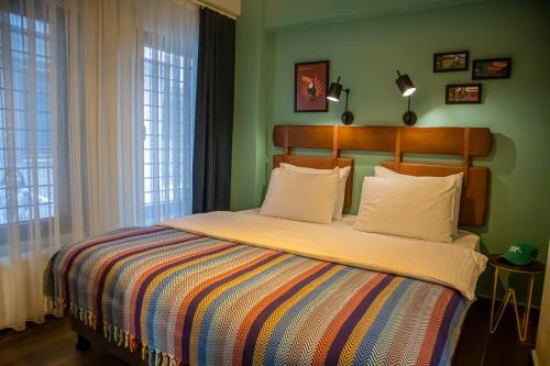 - une chambre avec un grand lit et une couverture colorée dans l'établissement The Abies, à Çanakkale
