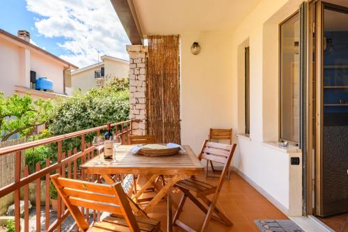 y balcón con mesa y sillas de madera. en Casa Oleandri, en Santa Maria Navarrese