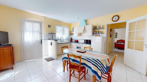Il comprend une cuisine équipée d'une table et de chaises. dans l'établissement La Terrasse du Port de Saint Gilles, à Saint-Gilles-Croix-de-Vie