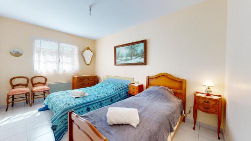 een slaapkamer met 2 bedden en een tafel en stoelen bij La Terrasse du Port de Saint Gilles in Saint-Gilles-Croix-de-Vie