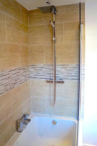 a bathroom with a shower with a bath tub at The Stables, 2 Plough Square in Glanton