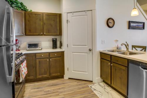 a kitchen with wooden cabinets and a refrigerator at 2 Mi to Zootah Providence Townhome with Fireplaces in Logan
