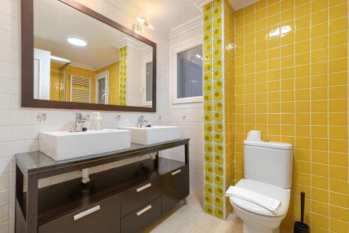 a bathroom with two sinks and a mirror and a toilet at Apartamento reformado en zona residencial con garaje y wifi in Bilbao