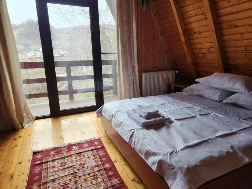 un dormitorio con una cama con un gato sobre ella en Casa Edenland Doftana, en Trăisteni