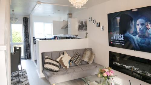 a living room with a couch and a tv at Milton Keynes Luxury Short Stay House with WIFI and Free Parking in Wolverton