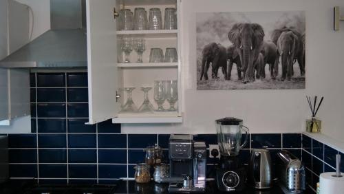 una cocina con encimera con licuadora y elefantes en la pared en Milton Keynes Luxury Short Stay House with WIFI and Free Parking en Wolverton