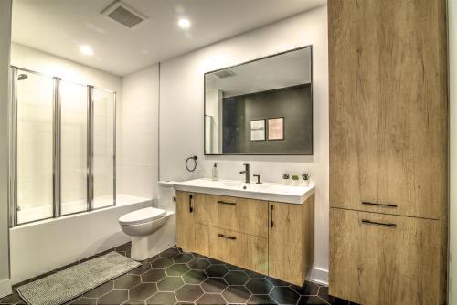 La salle de bains est pourvue d'un lavabo, de toilettes et d'un miroir. dans l'établissement Chalet Haut-Bois - Hiking, Skiing and Spa, à Morin Heights