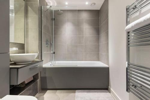 ein Badezimmer mit einer Badewanne und einem Waschbecken in der Unterkunft Luxury Double bedroom in Gallions Reach in Beckton